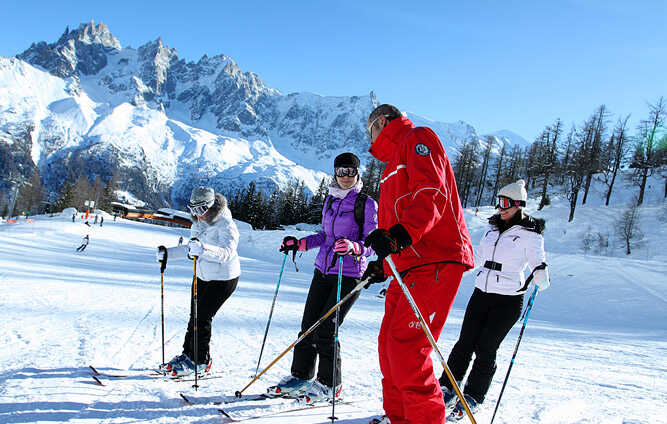 An ESF ski instructor in a lessoon with a group of solo skiers